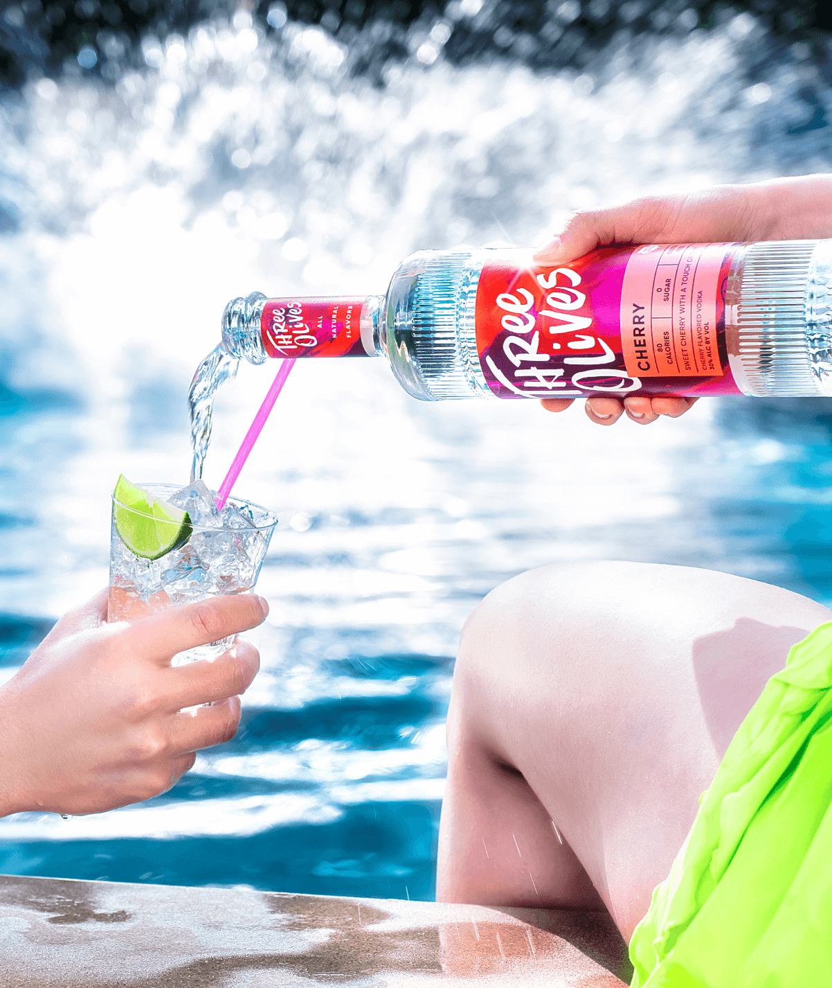 Three olives cherry bottle being poured into cocktail glass